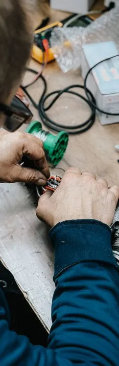 Electrician soldering wiring connections for commercial electrical project