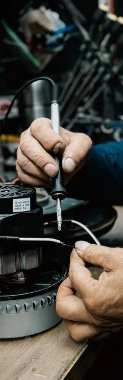 Electrician performing emergency electrical repair on industrial motor equipment