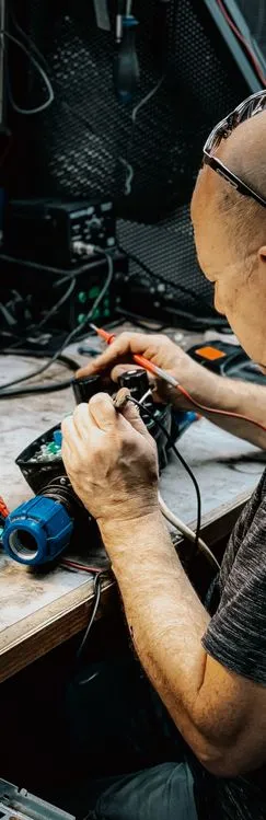 Technician using multimeter to test electronic components during project execution
