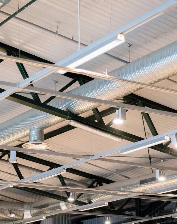 Industrial facility with high-bay LED lighting illuminating heavy equipment and steel structural framework