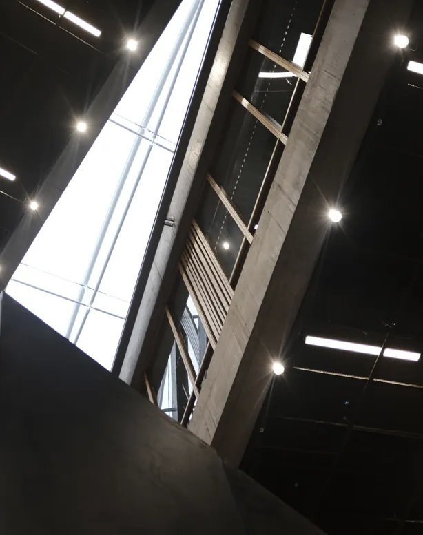 Large warehouse interior with rows of LED panel lights illuminating stacked pallets and distribution aisles