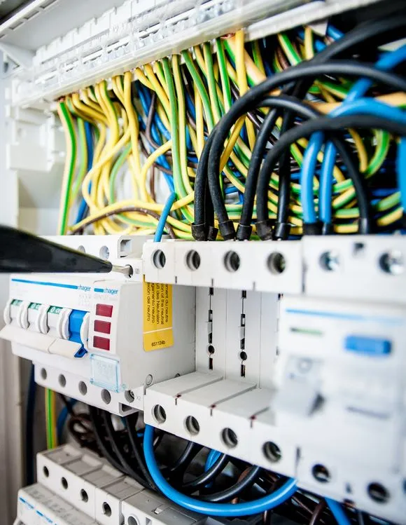 Electrician working on motor wiring with tools and cables
